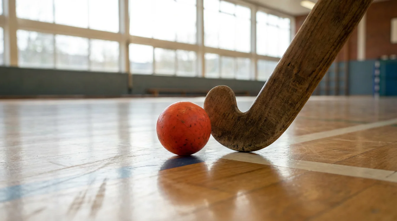 Zaalhockeybal en stick op indoor sportvloer